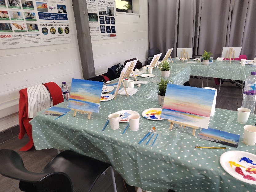 Paint and Chat tables set with easels, canvases and painting materials